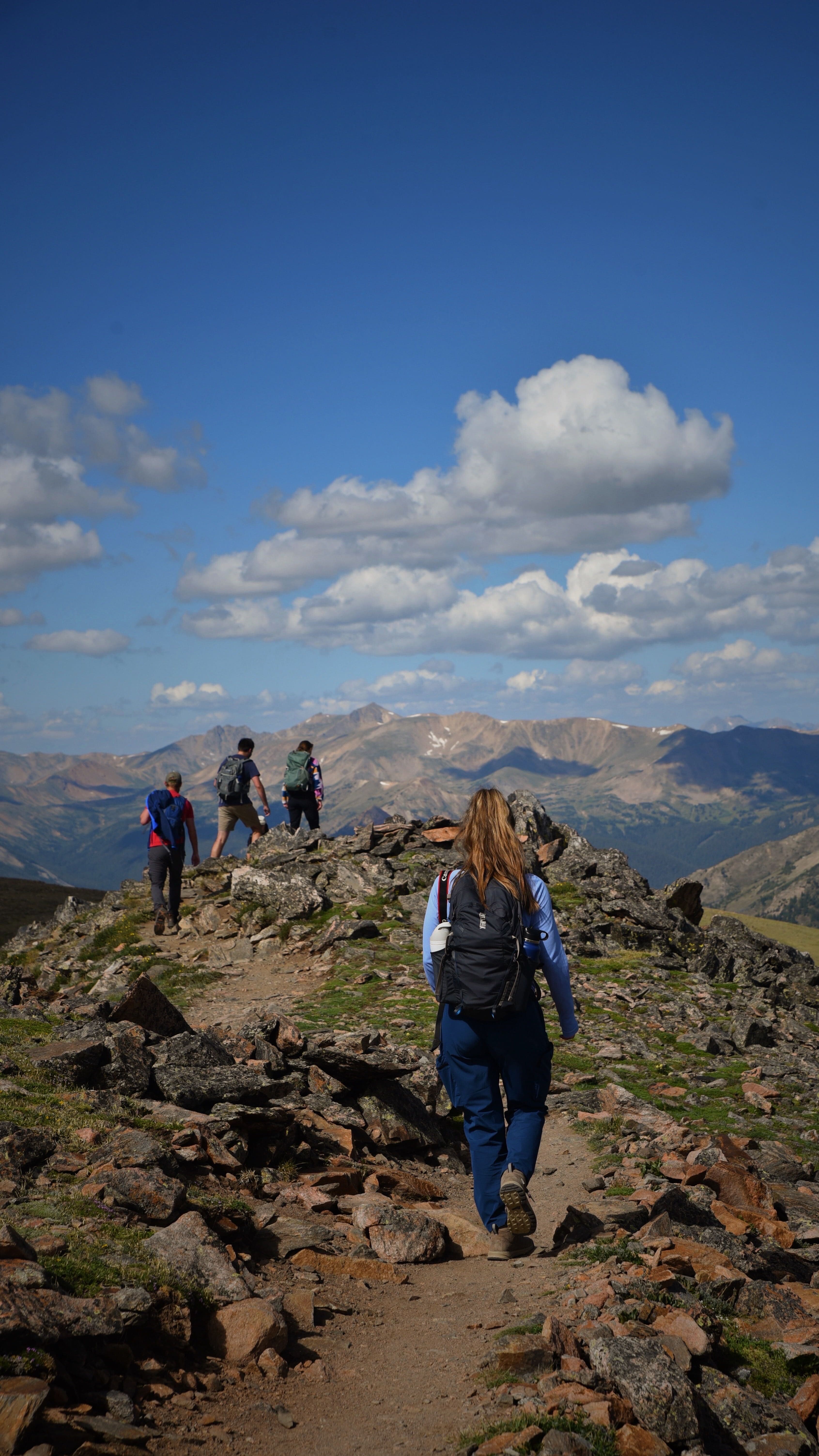 Denver Hiking club on a ridgeline above the mountains